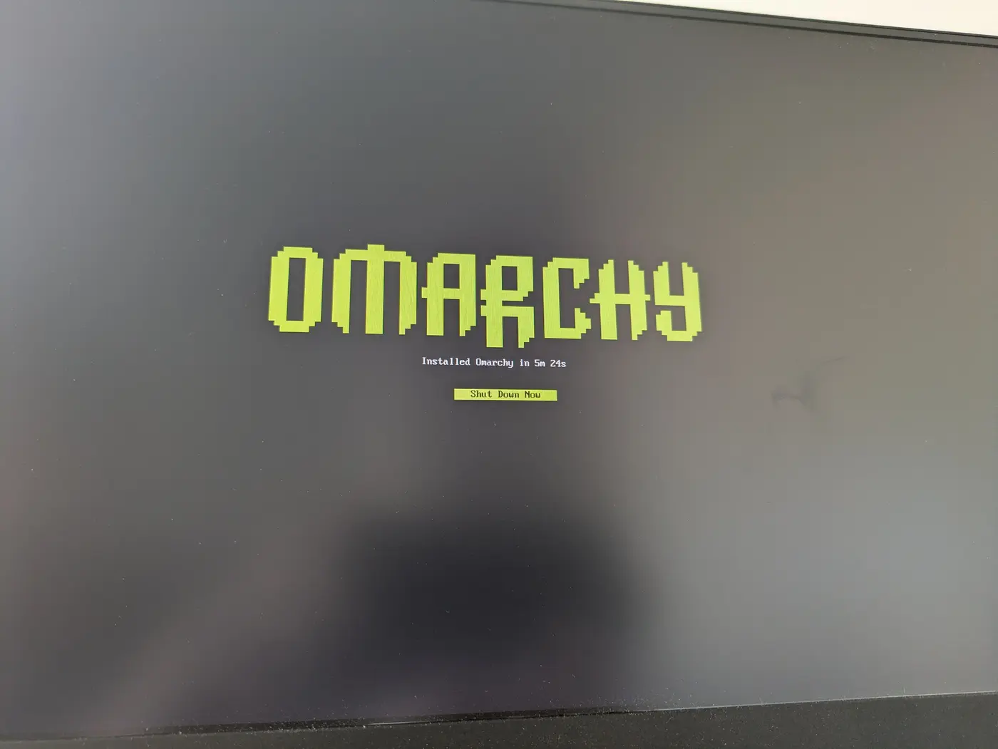 tater1’s monitor at the end of its Omarchy install, reading ‘Installed Omarchy in 5m 24s’ above a Shut Down Now button