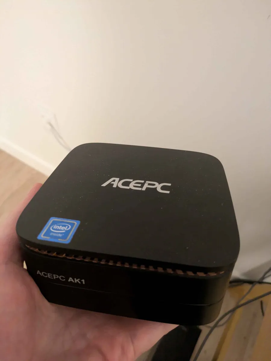 tater1, a small black ACEPC AK1 mini PC with an Intel sticker, held in one hand